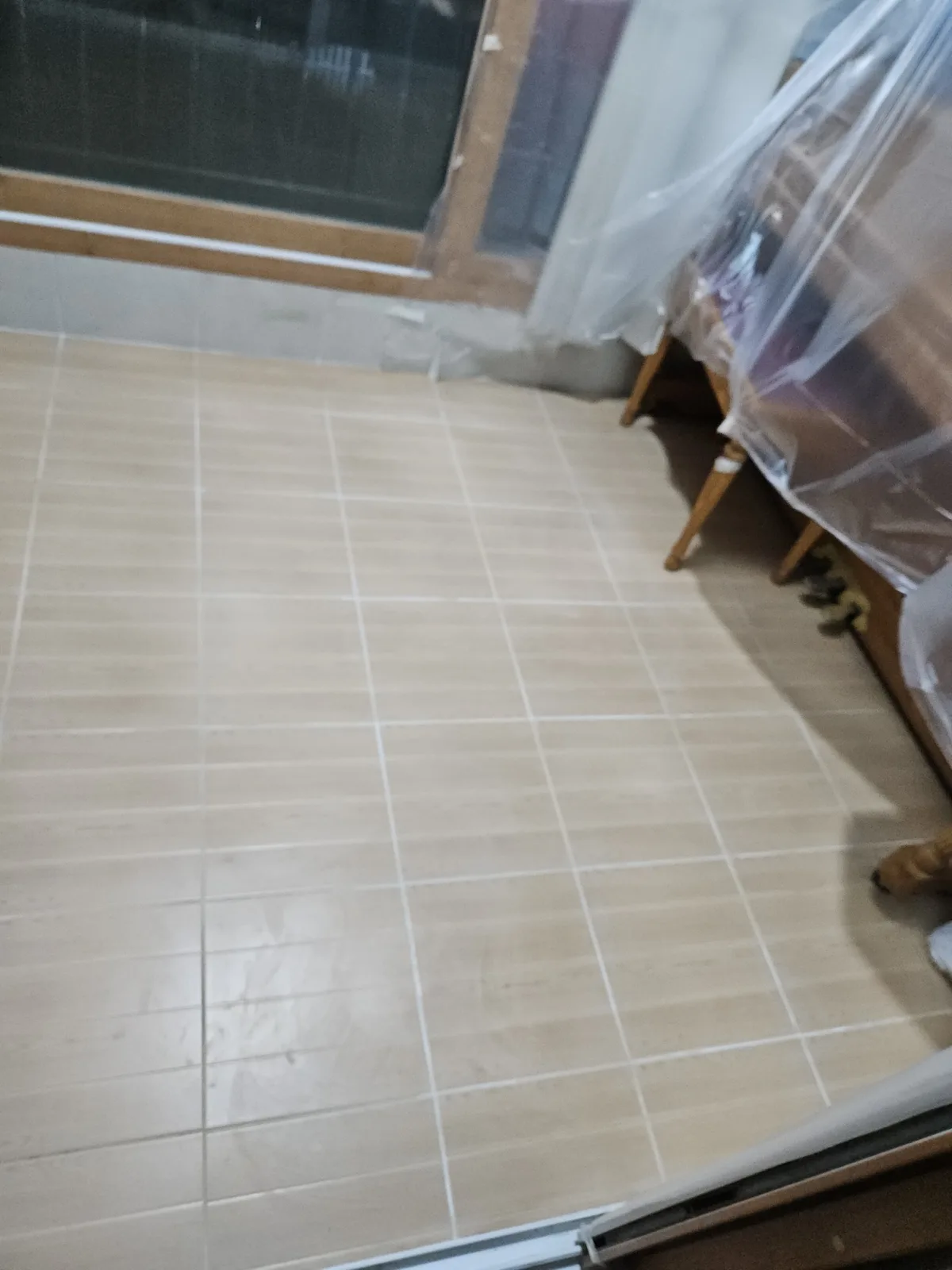 베이지 톤 바닥 타일이 넓게 시공되어 있고 줄눈은 흰색으로 깔끔하게 마감되어 있음.